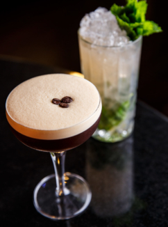 espresso martini and mojito cocktails on a bar table