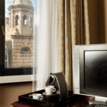 Privilege room, coffee machine and TV on desk with a view of Leicester out of the window
