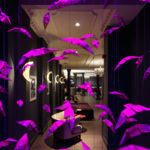 Purple origami artwork hanging in the hotel window, with reception visible behind